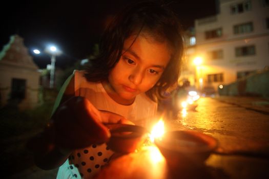 NEPAL, Kathmandu: A child lights candles at a celebration in Kathmandu, Nepal on September 21, 2015, one day after the government unveiled the country's first democratic constitution in a historic step. Out of the 598 members of the Constituent Assembly, 507 voted for the new constitution, 25 voted against, and 66 abstained in a vote on September 16, 2015. The event was marked with fireworks and festivities, but also with protests organized by parties of the Tharu and Madhesi ethnic communities.Photos taken by Newzulu contributor Dinesh Shrestha show the Nepalese people lighting candles to mark new chapter in the history of their country.