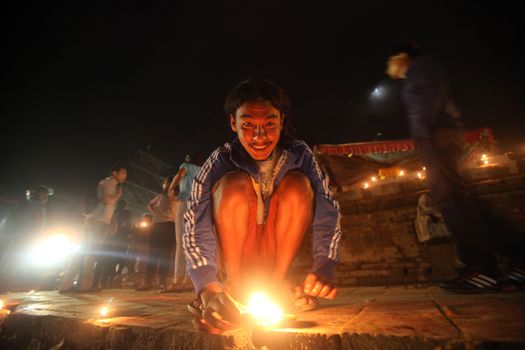 NEPAL, Kathmandu: A man lights candles at a celebration in Kathmandu, Nepal on September 21, 2015, one day after the government unveiled the country's first democratic constitution in a historic step. Out of the 598 members of the Constituent Assembly, 507 voted for the new constitution, 25 voted against, and 66 abstained in a vote on September 16, 2015. The event was marked with fireworks and festivities, but also with protests organized by parties of the Tharu and Madhesi ethnic communities.Photos taken by Newzulu contributor Dinesh Shrestha show the Nepalese people lighting candles to mark new chapter in the history of their country.