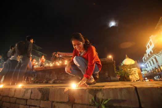 NEPAL, Kathmandu: A woman lights candles at a celebration in Kathmandu, Nepal on September 21, 2015, one day after the government unveiled the country's first democratic constitution in a historic step. Out of the 598 members of the Constituent Assembly, 507 voted for the new constitution, 25 voted against, and 66 abstained in a vote on September 16, 2015. The event was marked with fireworks and festivities, but also with protests organized by parties of the Tharu and Madhesi ethnic communities.Photos taken by Newzulu contributor Dinesh Shrestha show the Nepalese people lighting candles to mark new chapter in the history of their country.