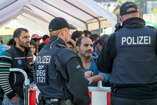 GERMANY, Passau: Security officials talk with a refugee waiting in long queues in the border town of Passau, Germany on September 21, 2015 amid the reintroduction of border controls in Germany, Austria, and a number of other EU countries, aimed at slowing the flow of refugees from war-torn Syria.