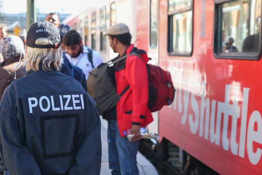 GERMANY, Passau: Security officials stand guard as refugees wait in long queues in the border town of Passau, Germany on September 21, 2015 amid the reintroduction of border controls in Germany, Austria, and a number of other EU countries, aimed at slowing the flow of refugees from war-torn Syria.