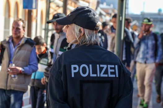 GERMANY, Passau: Security officials stand guard as refugees wait in long queues in the border town of Passau, Germany on September 21, 2015 amid the reintroduction of border controls in Germany, Austria, and a number of other EU countries, aimed at slowing the flow of refugees from war-torn Syria.