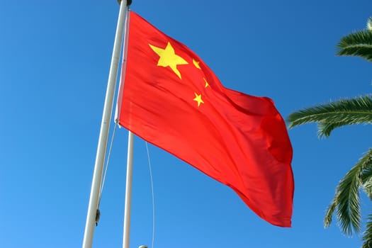 Chinese national flag with blue sky as background. Nice, France