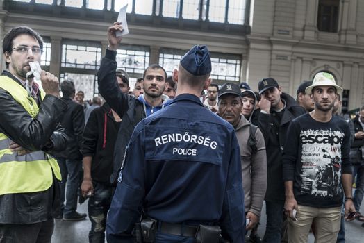 HUNGARY, Roszke: A man is held back by police as refugees crowd Budapest's Keleti Train Station on September 8 2015, as Europe's refugee crisis continues. 