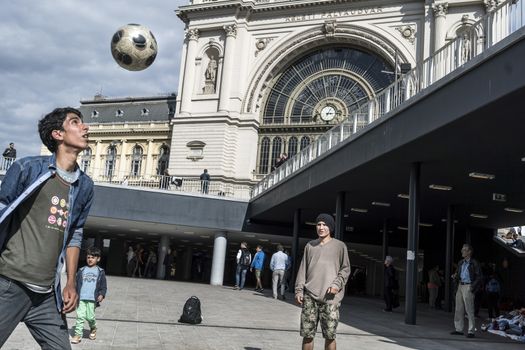 HUNGARY, Roszke: Young boys play football as refugees crowd Budapest's Keleti Train Station on September 8 2015, as Europe's refugee crisis continues. 