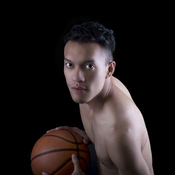 Asian young basketball player on black background