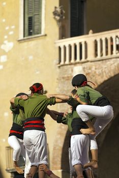 VERONA, ITALY - SEPTEMBER 19, 2015: Tocati, International festival of street games. Castells Performance of Xiquets d'Alcover of Tarragona, Catalonia, Spain. The Castells (Castle in Catalan) is a human tower - UNESCO intangible cultural heritage of humanity
