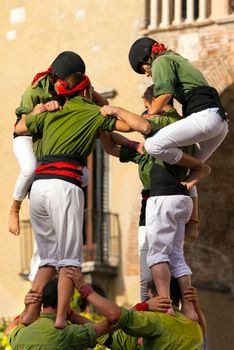 VERONA, ITALY - SEPTEMBER 19, 2015: Tocati, International festival of street games. Castells Performance of Xiquets d'Alcover of Tarragona, Catalonia, Spain. The Castells (Castle in Catalan) is a human tower - UNESCO intangible cultural heritage of humanity