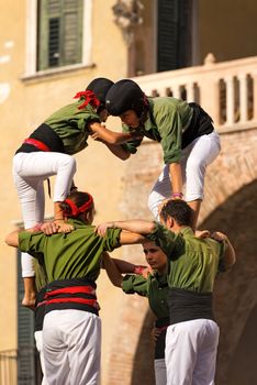 VERONA, ITALY - SEPTEMBER 19, 2015: Tocati, International festival of street games. Castells Performance of Xiquets d'Alcover of Tarragona, Catalonia, Spain. The Castells (Castle) is a human tower - UNESCO cultural heritage