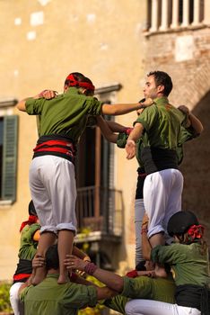 VERONA, ITALY - SEPTEMBER 19, 2015: Tocati, International festival of street games. Castells Performance of Xiquets d'Alcover of Tarragona, Catalonia, Spain. The Castells (Castle) is a human tower - UNESCO cultural heritage