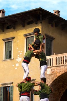 VERONA, ITALY - SEPTEMBER 19, 2015: Tocati, International festival of street games. Castells Performance of Xiquets d'Alcover of Tarragona, Catalonia, Spain. The Castells (Castle) is a human tower - UNESCO cultural heritage