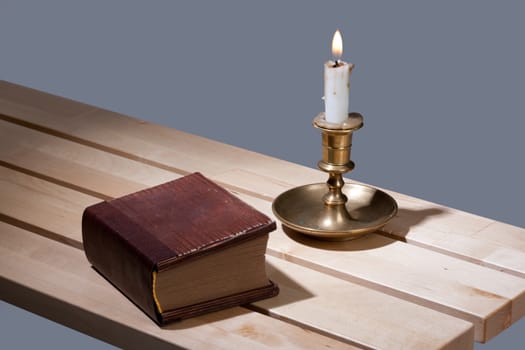 Old book and candle in an old candlestick