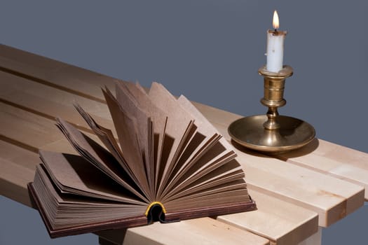 Old book and candle in an old candlestick