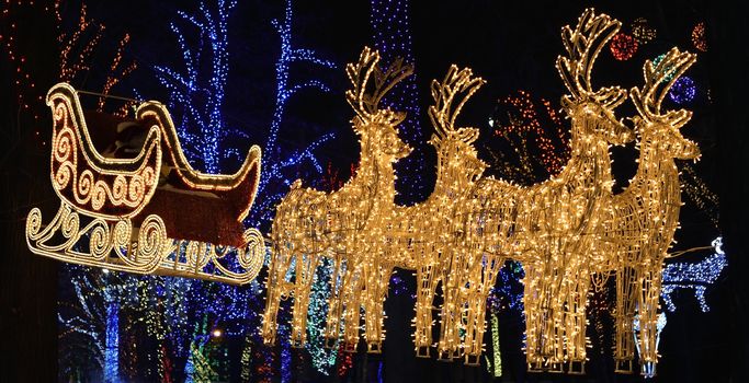 Electronic yellow glowing flying sleigh of Santa Claus with deers