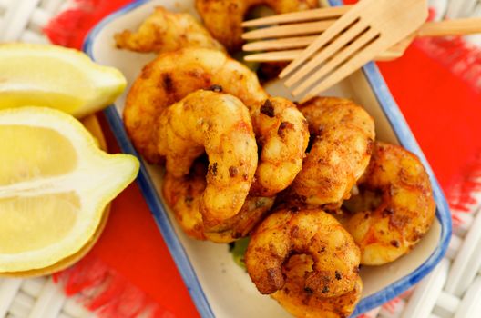 Delicious Grilled Prawns with Sliced Lemon and Wooden Forks closeup on Red Napkin. Selective Focus