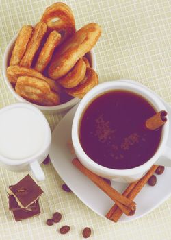 Arrangement of Coffee Cup, Milk and Puff Pastry with Chocolate, Sugar and Cinnamon Sticks. Retro Styled