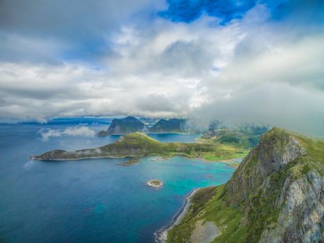 Aerial scenic view of peaks on Lofoten islands covered by scattered clouds