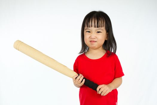 Portrait of a young little Chinese girl holding baseball bat with angry expression in white isolated background.