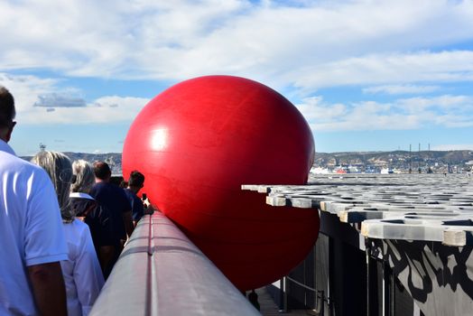 FRANCE, Marseille : This picture taken on September 19, 2015 in Marseille, shows a red ball on the roof of Mucem museum. New York based artist Kurt Perschke's RedBall project stopped off in Marseille between September 19 and 25, 2015. The project involves installing a five meter wide red ball in different places from town to town. 