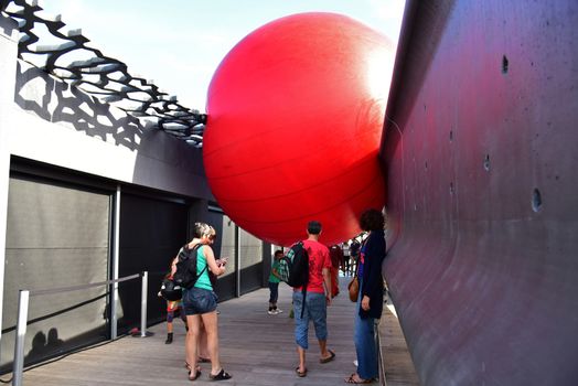 FRANCE, Marseille : This picture taken on September 19, 2015 in Marseille, shows a red ball on the roof of Mucem museum. New York based artist Kurt Perschke's RedBall project stopped off in Marseille between September 19 and 25, 2015. The project involves installing a five meter wide red ball in different places from town to town. 