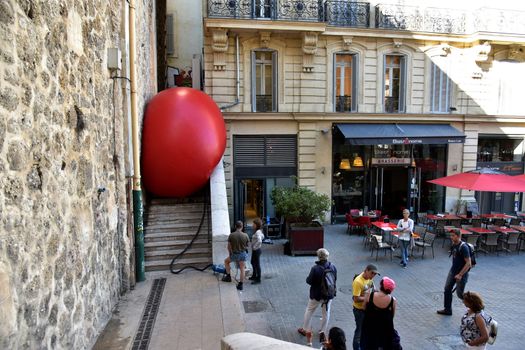 FRANCE, Marseille : This picture taken on September 19, 2015 in Marseille, shows a red ball on the stairs of a street in Marseille. New York based artist Kurt Perschke's RedBall project stopped off in Marseille between September 19 and 25, 2015. The project involves installing a five meter wide red ball in different places from town to town. 