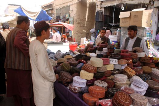 AFGHANISTAN, Kandahar: Crowds are out shopping in Charso Bazaar for Eid on September 22, 2015. Men in traditional dress and women in burqas buy dried fruits, biscuits, clothes, shoes, hats and things for their homes in Charso Bazaar, Kandahar. 