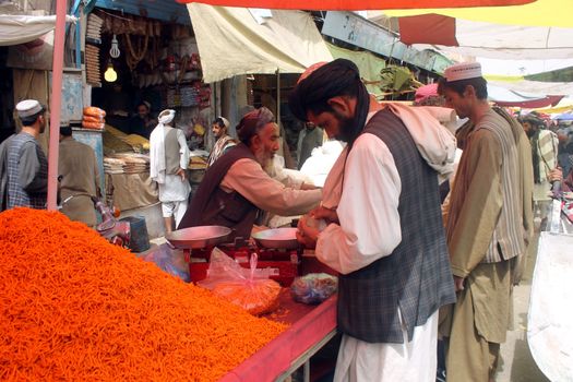 AFGHANISTAN, Kandahar: Crowds are out shopping in Charso Bazaar for Eid on September 22, 2015. Men in traditional dress and women in burqas buy dried fruits, biscuits, clothes, shoes, hats and things for their homes in Charso Bazaar, Kandahar. 