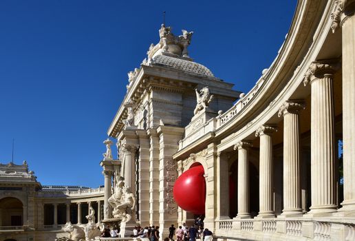 FRANCE, Marseille : This picture taken on September 19, 2015 in Marseille, shows a red ball between columns of Palais de Longchamp. New York based artist Kurt Perschke's RedBall project stopped off in Marseille between September 19 and 25, 2015. The project involves installing a five meter wide red ball in different places from town to town. 