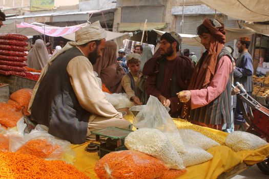 AFGHANISTAN, Kandahar: Crowds are out shopping in Charso Bazaar for Eid on September 22, 2015. Men in traditional dress and women in burqas buy dried fruits, biscuits, clothes, shoes, hats and things for their homes in Charso Bazaar, Kandahar. 