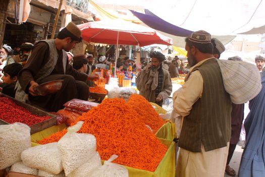 AFGHANISTAN, Kandahar: Crowds are out shopping in Charso Bazaar for Eid on September 22, 2015. Men in traditional dress and women in burqas buy dried fruits, biscuits, clothes, shoes, hats and things for their homes in Charso Bazaar, Kandahar. 