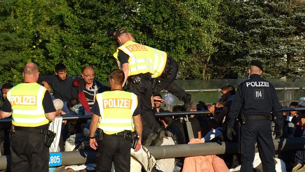 GERMANY, Freilassing: Refugees being stopped by police as they enter Germany from Austria at Freilassing train station, on September 21, 2015. 	The station has become a huge processing camp for migrants heading to Germany, following strict border controls being introduced. German police are now boarding trains from Austria and checking the documents of travellers. 