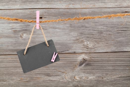 Black board of slate on old rustic wooden background,