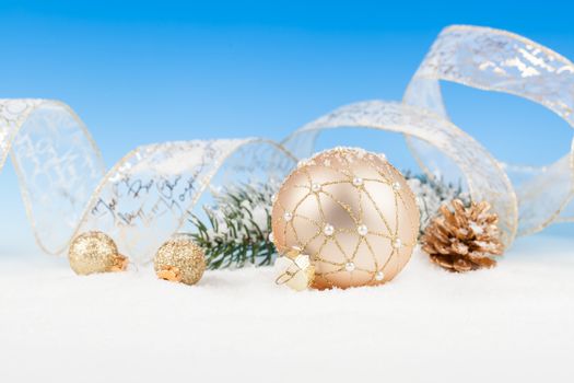 Christmas balls and fir branches with decorations over blue background