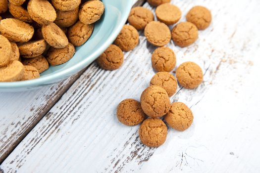 Dutch candy pepernoot with bowl on white wooden background