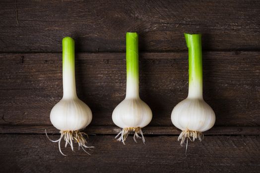 Fresh young garlic in an old wooden box top view close up