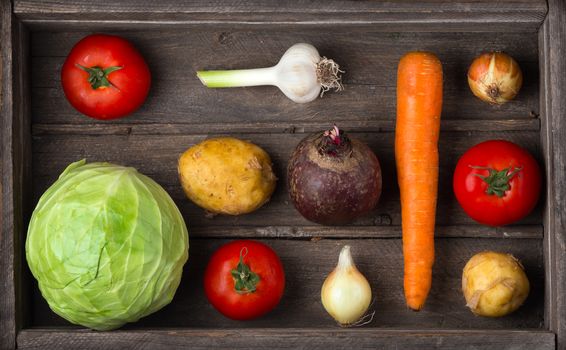 Ingredients for borscht, beetroot soup, beet soup: cabbage, carrots, onions, garlic in a wooden box. Harvest vegetables. The concept of vegetarianism, veganism, healthy eating