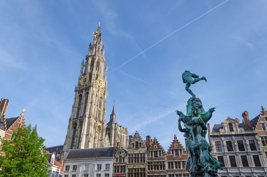 Statue of Brabo, throwing the giant's hand into the Scheldt River and the Cathedral of our Lady at Grand Place in Antwerp, Belgium. 