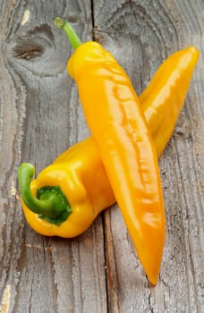 Two Perfect Ripe Yellow Ramiro Peppers isolated on Rustic Wooden background