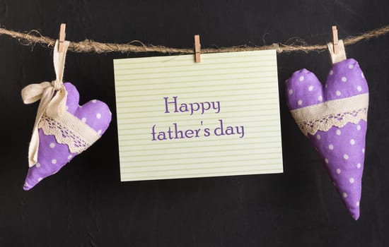 message card with text happy father's day and handmade hearts of the cloth with polka dots on a rope with clothespins, greeting and love concept,  congratulations