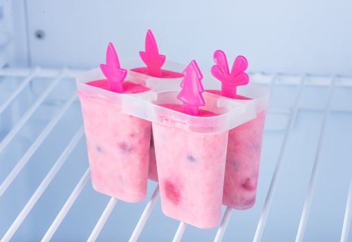 Homemade ice cream, frozen yogurt with blackberries, blueberries and raspberries on a shelf in the freezer