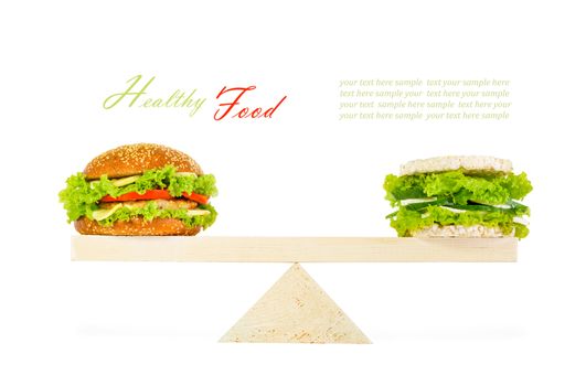 The concept of a healthy food, diet, losing weight. classic burger and a healthy burger with wholegrain cereal crispbreads, vegetables, herbs and cheese on scales. Isolated on white background
