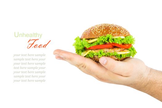 The concept of unhealthy diet, harmful food, overweight, weight loss, diet. Man's hand holding a burger isolated on white background, close up