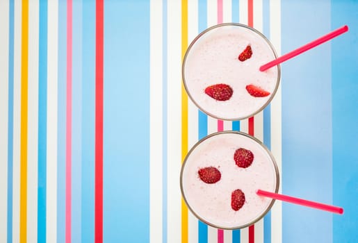 Delicious, nutritious and healthy fresh strawberry yogurt in glass beakers and drinking straws on bright background