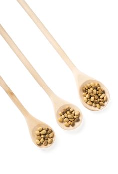 Soybeans in a wooden spoons isolated on white background