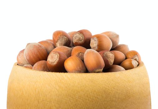 hazelnuts in a wooden bowl isolated on white background close up