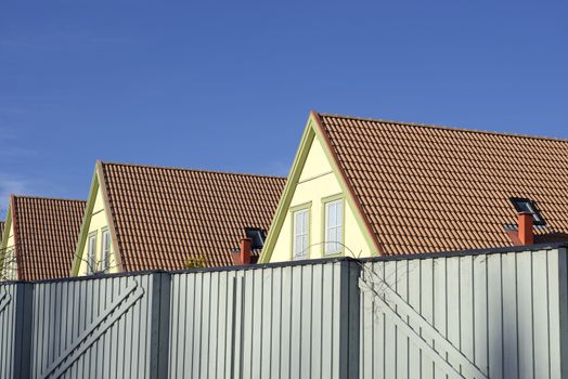 Photograph of a new house rooftop against a clear blue sky.