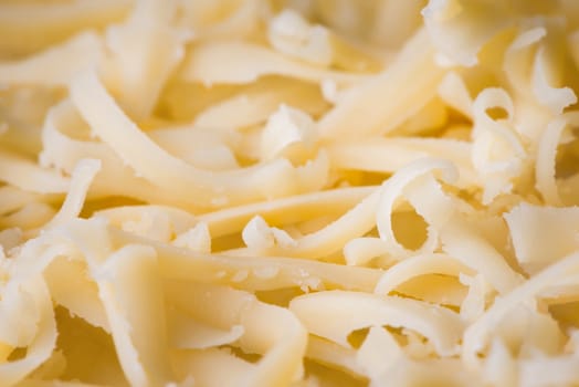 Grated fresh cheese close up, ingredient for pizza