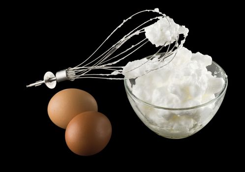 whipping eggs  for cream with whisk and eggs Isolated on black background