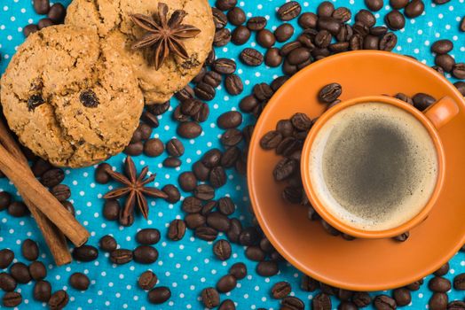 ceramic cup with coffee espresso on a bright blue background, oatmeal cookies, cinnamon, star anise, top view