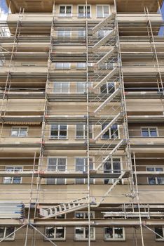 Thermal insulation being installed with scaffolding around the building